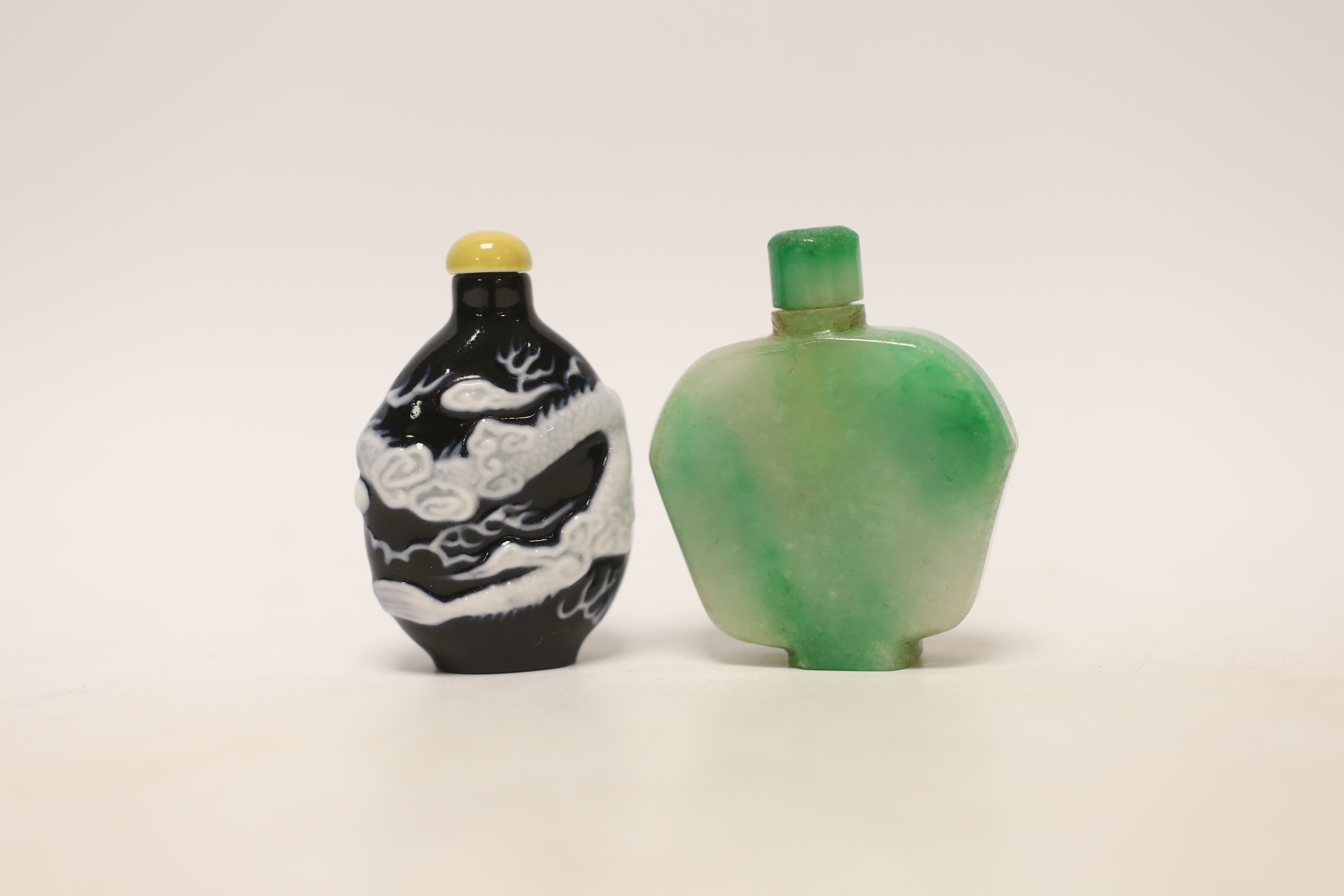 A Chinese jadeite snuff bottle and a slip decorated porcelain ‘dragon’ snuff bottle